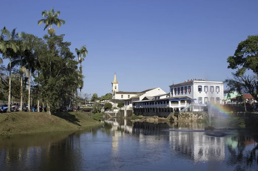 Vista panorâmica do centro histórico de Morretes com casarões coloniais coloridos e o Rio Nhundiaquara que corta a cidade.
